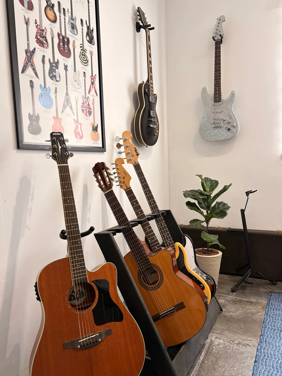 A Garage hoje: violões, guitarras e baixo junto à parede com instrumentos e um quadro de guitarras.